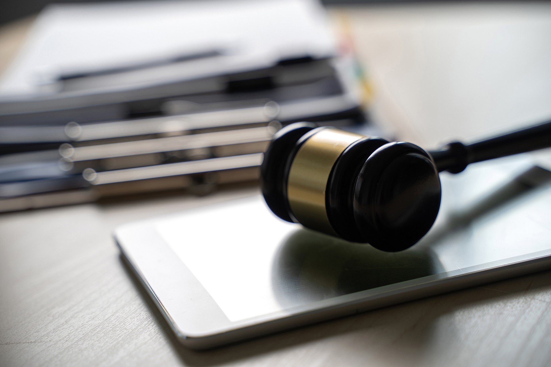 Close-Up Of Gavel On Digital Tablet At Desk